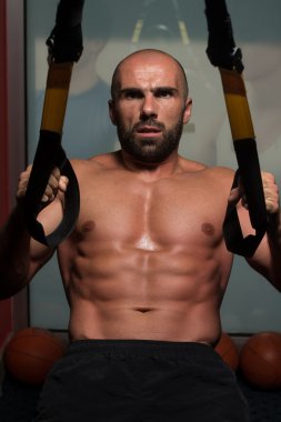 Trx Fitness askıları ile genç çekici adam eğitim