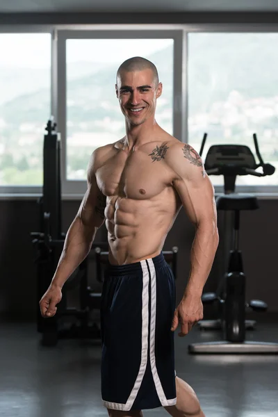 Muscular Man Flexing Muscles In Gym — Stock Photo, Image