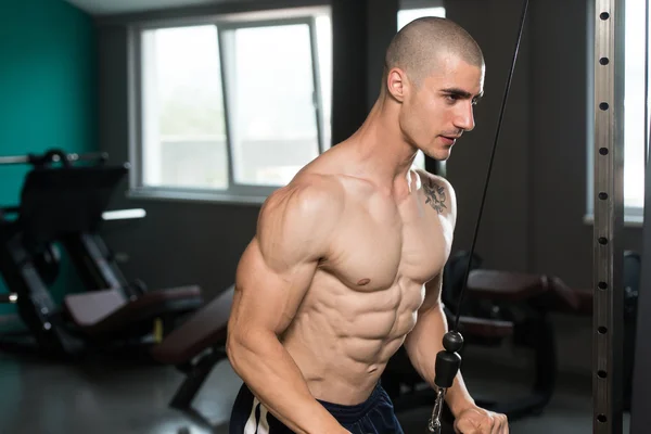 Junger Mann trainiert Trizeps im Fitnessstudio — Stockfoto