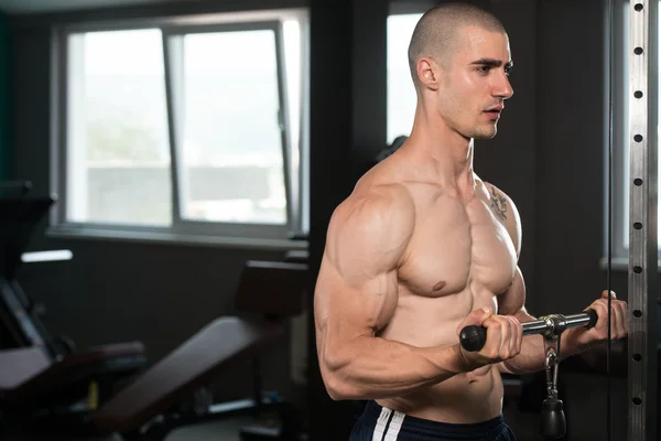 Jeune homme exerçant des biceps dans la salle de gym — Photo