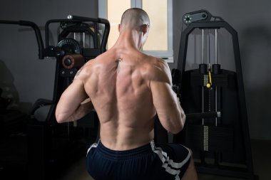 Kaslı adam arka için ağır egzersiz yaparak