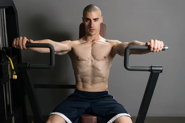 年轻人在健身房里锻炼胸部 — 图库照片