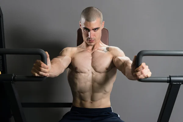 Młody mężczyzna wykonując klatki piersiowej w siłowni — Zdjęcie stockowe