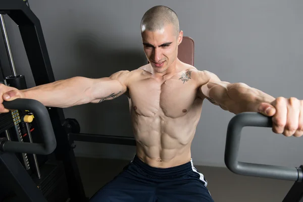 Jeune homme exerçant poitrine dans la salle de gym — Photo