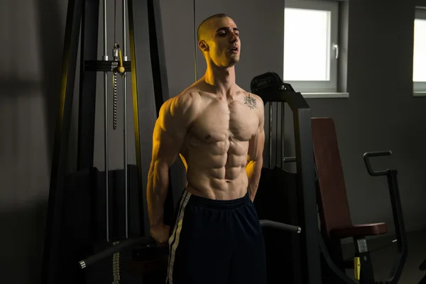 Młody człowiek wykonując triceps na siłowni — Zdjęcie stockowe
