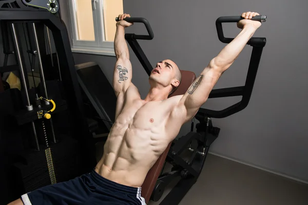 М'язистий чоловік робить важку вправу для плечей — стокове фото