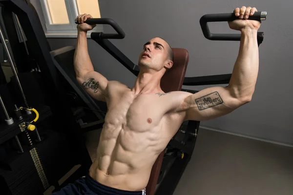 Homem muscular fazendo exercício de peso pesado para ombros — Fotografia de Stock