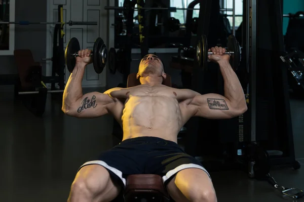 Bodybuilder trainiert Brust mit Kurzhanteln — Stockfoto