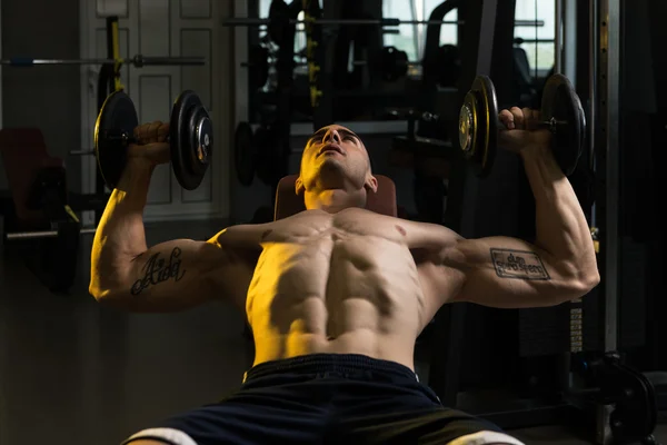 Hombre trabajando tríceps y pecho con sombrillas — Foto de Stock