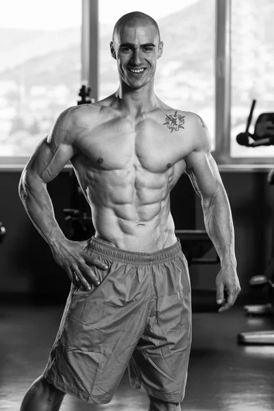 Hombre joven saludable Flexing Músculos —  Fotos de Stock