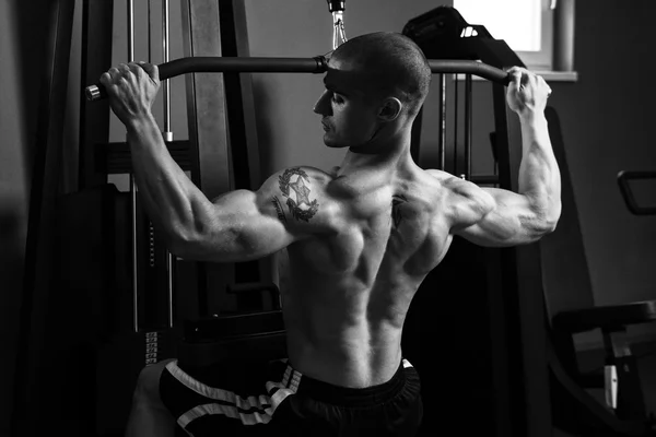 背部のための重い重量運動をしている若い男 — ストック写真
