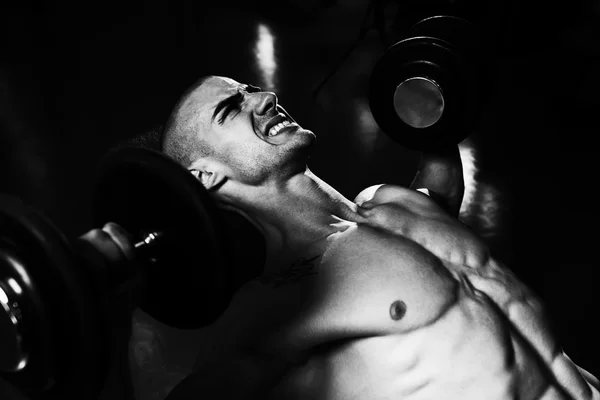 Joven en el gimnasio haciendo ejercicio en el pecho con sombrillas —  Fotos de Stock