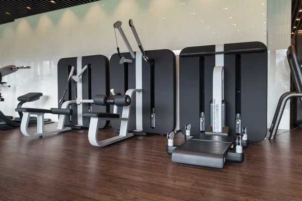 Intérieur de la nouvelle salle de gym moderne avec équipement — Photo