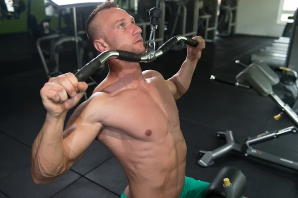 Uomo muscolare che fa esercizio fisico pesante per la schiena — Foto Stock