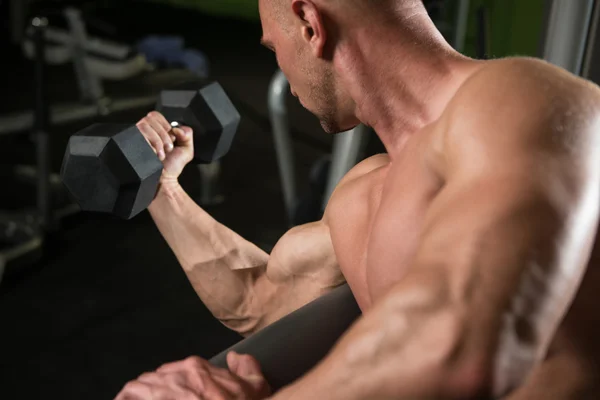 Mladý muž dělá cvičení pro Biceps s činkami — Stock fotografie