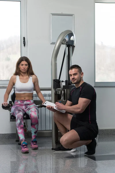 Trainer schrijven op Klembord terwijl vrouw opleiding Triceps — Stockfoto