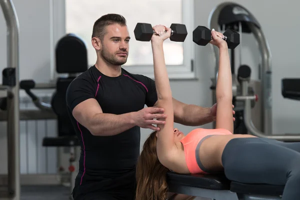 Personal trainer aiutare il cliente in palestra — Foto Stock