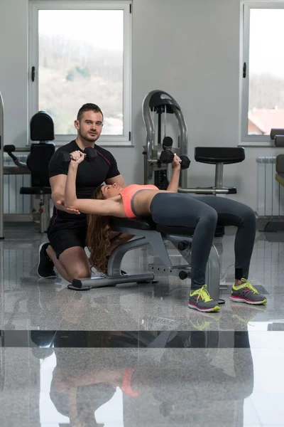 Personal Trainer hilft Klient im Fitnessstudio — Stockfoto