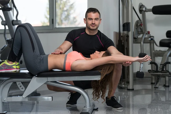 Personal Trainer hilft Klient im Fitnessstudio — Stockfoto