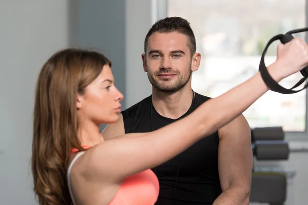 Entraîneur personnel aidant femme sur les sangles de fitness Trx — Photo