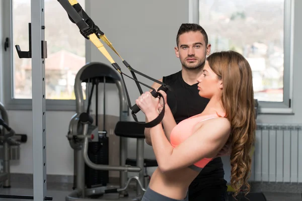 Frau mit Personal Trainer trainiert trx Fitnessbänder — Stockfoto