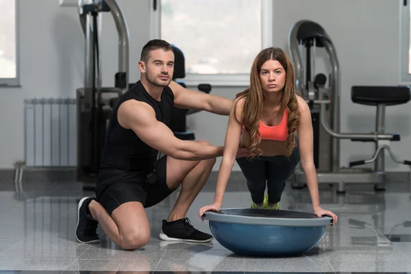 Personal Trainer aiutare la donna su Bosu spingere Ups — Foto Stock