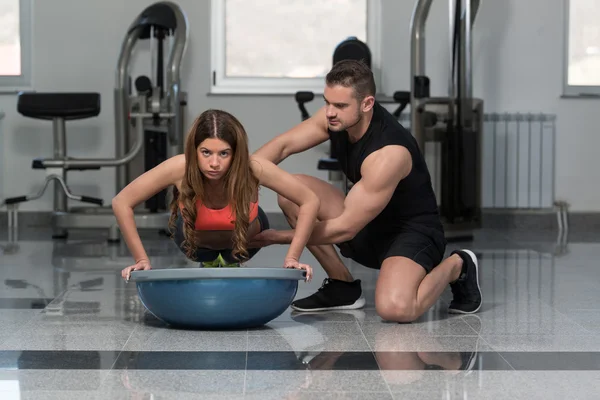 Personal Trainer helpt vrouw op Bosu Push Ups — Stockfoto