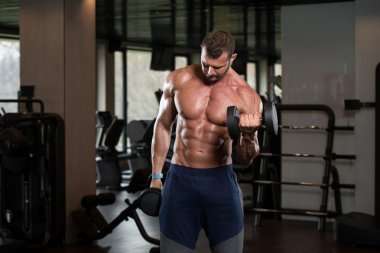 Vücut geliştirmeci pazı bukleler Dumbbells ile gerçekleştirme