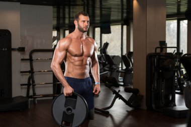 Ağırlıkları elinde tutan adam uygun