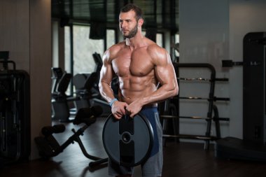 Ağırlıkları elinde tutan adam uygun