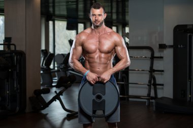 Ağırlıkları elinde tutan vücut geliştirmeci