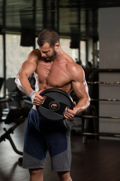 Junger Mann trainiert Bauchmuskeln mit Gewichten — Stockfoto