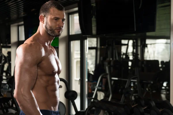 Людина в спортзалі показує його добре навчене тіло — стокове фото