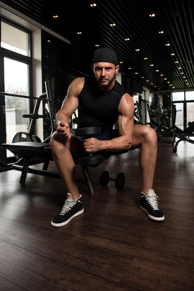 Muskulös man tränar biceps med hantlar — Stockfoto
