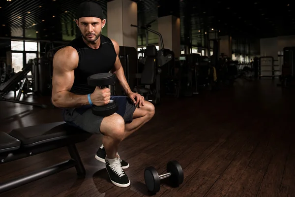 Mannen i gymmet träna biceps med hantlar — Stockfoto