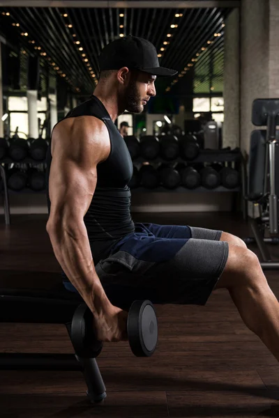 Homem muscular exercício bíceps com halteres — Fotografia de Stock