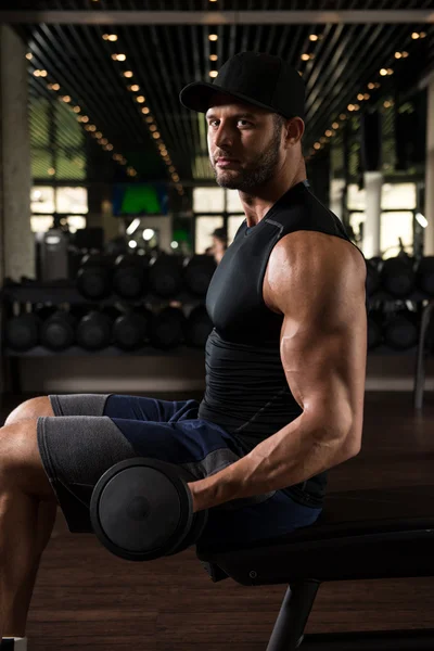 Muskulös man tränar biceps med hantlar — Stockfoto