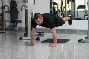 Trx Fitness askıları ile genç çekici adam eğitim