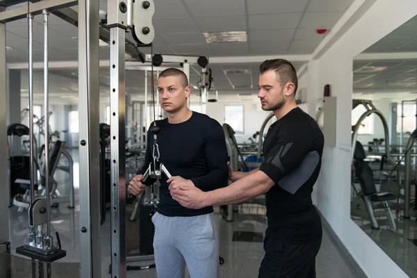 Entraîneur de gymnase aider jeune homme sur Triceps — Photo
