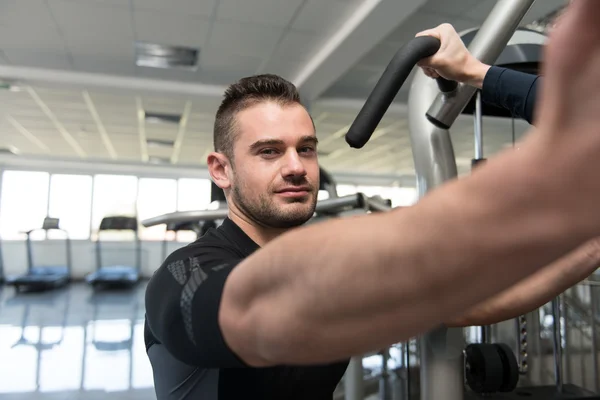 Fitnesscoach hilft jungem Mann bei Brustgymnastik — Stockfoto