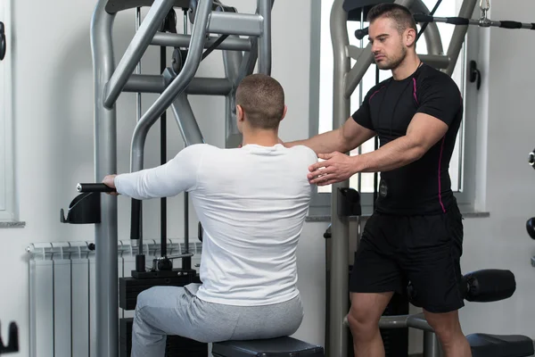 Personal trainer aiutare il cliente in palestra — Foto Stock