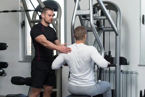 Man Train Back On Machine With Personal Trainer — Stock Photo, Image