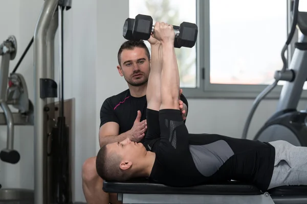 Personal Trainer ajudando o homem no exercício tríceps — Fotografia de Stock