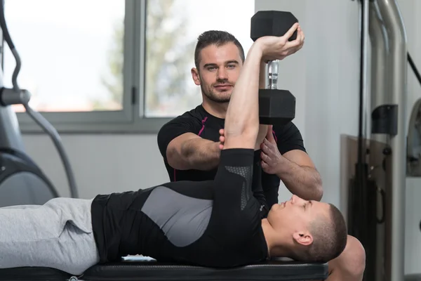 Entraîneur de gymnase aider l'homme sur l'exercice de poitrine — Photo