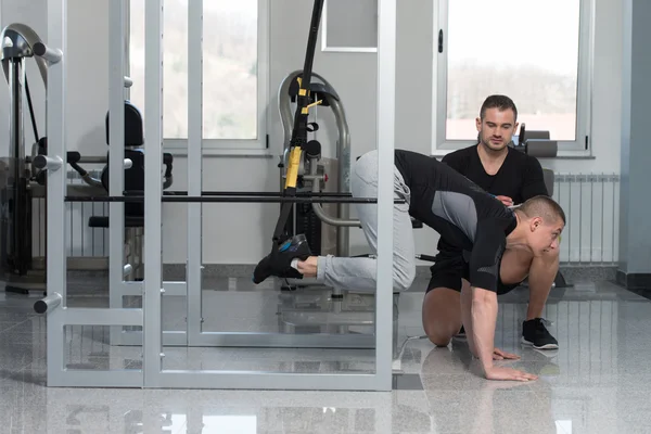 Personal Trainer helpt Man op Trx Fitness riemen — Stockfoto