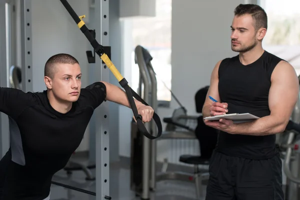 Eğitmen Trx Fitness askıları Pano adam ile — Stok fotoğraf