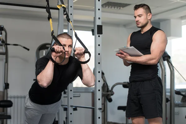 Trainer With Clipboard Man On Trx Fitness Straps — Stock Photo, Image