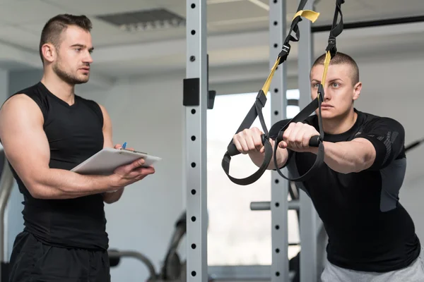 Eğitmen Trx Fitness askıları Pano adam ile — Stok fotoğraf