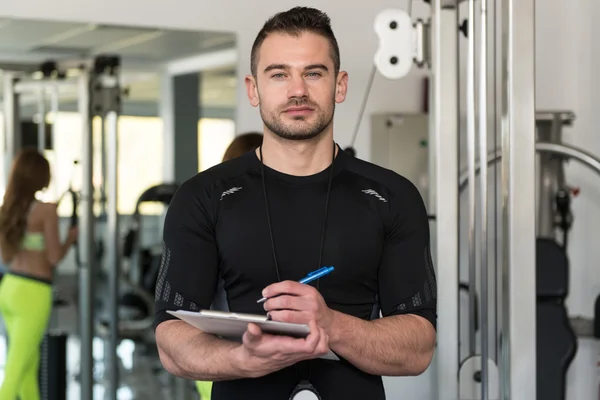 Knappe mannelijke Trainer met Klembord In een sportschool — Stockfoto