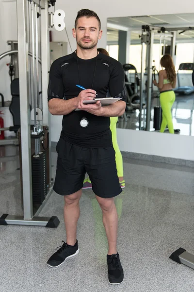 Handsome Male Trainer With Clipboard In A Gym — Stock Photo, Image